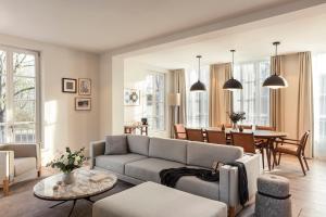 a living room with a couch and a table at Le Grand Pavillon Chantilly in Chantilly