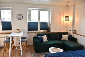 - un salon avec un canapé vert et une table dans l'établissement Kristella Kesklinna Apartment, à Haapsalu