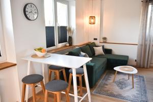 uma sala de estar com um sofá, uma mesa e cadeiras em Kristella Kesklinna Apartment em Haapsalu