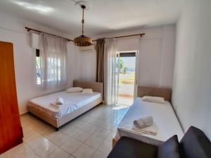 a bedroom with two beds and a couch and a window at Prassas Sea View in Nea Potidaea