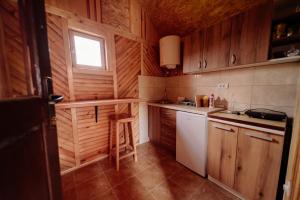 a small kitchen with wooden cabinets and a window at Bakalovina House in Nova Varoš