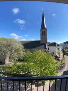 a view from a balcony of a church with a clock tower at Boutique Hotel LE•BAR in Zandvoort