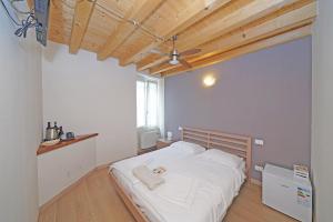 una camera da letto con un grande letto con lenzuola bianche di B&B San Rocco a Gargnano