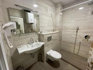 a bathroom with a sink and a toilet and a shower at De Luxe Studio Burgas, City Center in Burgas City