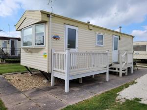a mobile home with a porch and two chairs at 6 Berth Sealands Ingoldmells (Arizona SL) in Ingoldmells