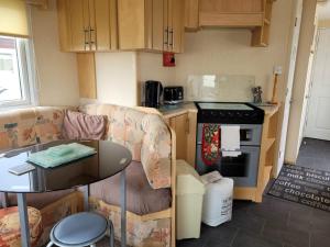 a kitchen with a couch and a table in a room at 6 Berth Sealands Ingoldmells (Arizona SL) in Ingoldmells