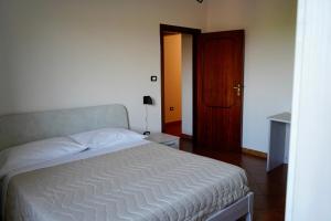 um quarto com uma cama branca e uma porta de madeira em Atomos em Alvignano