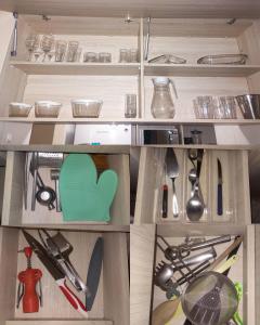 um armário de madeira cheio de muitos utensílios de cozinha em Flat 26º andar com vista para o mar- Próximo ao shopping e à praia de Boa Viagem em Recife