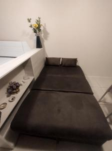 Sofá negro en una habitación con mesa en Flat 26º andar com vista para o mar- Próximo ao shopping e à praia en Recife