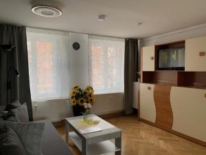 ein Wohnzimmer mit einer Blumenvase auf dem Tisch in der Unterkunft Ferienwohnung Nikolaiblick in Jüterbog