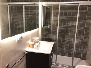 La salle de bains est pourvue d'un lavabo et d'une douche avec un miroir. dans l'établissement Yuhom casas con alma Galera 2º, à La Corogne