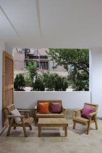 Duas cadeiras e um banco com almofadas num pátio em Eastside Suites em Majdal Shams