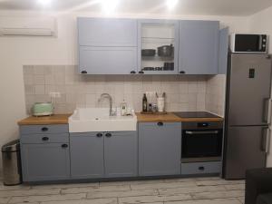 バルバッジョにあるAppartement Haute-Corse Calmeの白いキャビネット、シンク、冷蔵庫付きのキッチンが備わります。