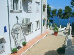 a white building with a view of the water at Apartments Villa La Riva - Seafront accommodation in Sutivan