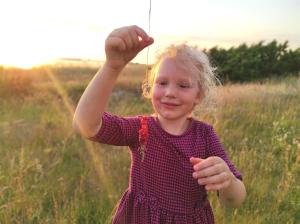 a little girl in a field holding a string at Kärdla Retrovisiit Saima in Kärdla