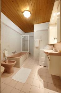 een badkamer met een bad, een toilet en een wastafel bij Ferienwohnung im Herzen Kalterns mit einer Terasse zum verlieben in Caldaro