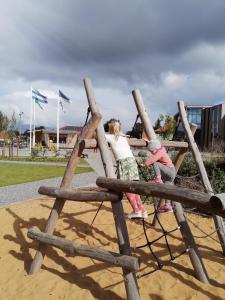 two little girls playing on a wooden playground at Kärdla Retrovisiit Saima in Kärdla