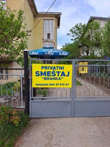 um sinal numa cerca em frente a uma casa em Apartman Branka em Niška Banja
