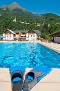 a swimming pool with blue water and mountains in the background at Apartment In Allemont in Allemont