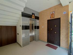 einen Flur mit zwei Aufzügen und einer Tür in einem Gebäude in der Unterkunft Srirengavilasam Elite - Srirangam in Tiruchchirāppalli