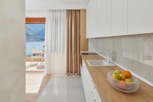 a kitchen with a bowl of fruit on a counter at Apartment Noa with Sea View in Kotor