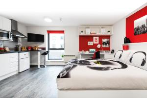 a bedroom with a large bed with a red wall at Yugo Explore - Arofan House in Cardiff