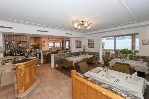 a restaurant with tables and chairs and a bar at Hotel Tristkogel in Saalbach-Hinterglemm