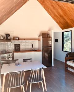 una cucina con tavolo, sedie e frigorifero di VILLA MORA Punta Colorada a Punta Colorada