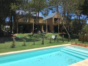 a house with a swimming pool in front of a house at VILLA MORA Punta Colorada in Punta Colorada
