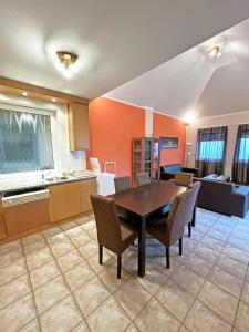 a kitchen and dining room with a table and chairs at Dunai Panorámás Apartman Dunaszentmiklóson in Dunaszentmiklós