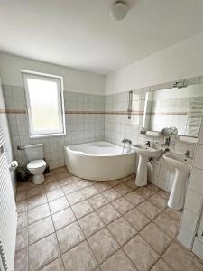 uma casa de banho com uma banheira, um WC e um lavatório. em Dunai Panorámás Apartman Dunaszentmiklóson em Dunaszentmiklós