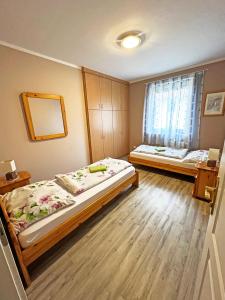 um quarto com 2 camas e um espelho em Dunai Panorámás Apartman Dunaszentmiklóson em Dunaszentmiklós