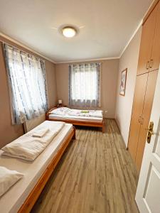 1 dormitorio con 2 camas y 2 ventanas en Dunai Panorámás Apartman Dunaszentmiklóson, en Dunaszentmiklós