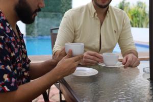 two men sitting at a table drinking coffee at Margarett Hotel in Valladolid +18 photos