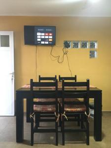 a dining room table with two chairs and a tv on the wall at Liquidambar in Federación