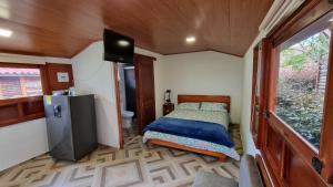 een kleine slaapkamer met een bed en een televisie. bij Villa GO in Suesca