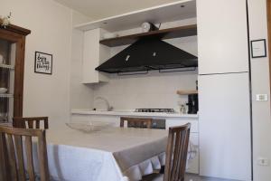 une cuisine avec une table et une hotte noire dans l'établissement City center Stabia apartment, à Castellammare di Stabia