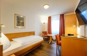 ein Hotelzimmer mit einem Bett und einem Tisch in der Unterkunft Hotel Restaurant Waldhorn Holzgerlingen in Holzgerlingen