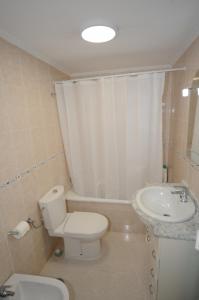 a white bathroom with a toilet and a sink at PLAYASOL Orangecosta 1 dormitorio in Benicàssim