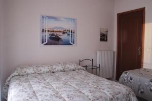 - une chambre avec un lit et une photo sur le mur dans l'établissement City center Stabia apartment, à Castellammare di Stabia