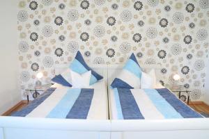 a bedroom with two beds with blue and white pillows at DEB 035 Ferienwohnung im Westerwald in Freirachdorf