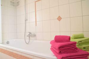 a bathroom with pink towels sitting on a bath tub at DEB 035 Ferienwohnung im Westerwald in Freirachdorf +26 photos
