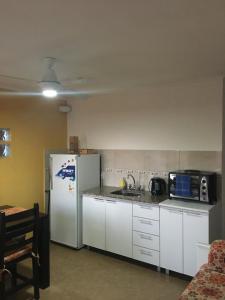 a kitchen with white cabinets and a refrigerator at Liquidambar in Federación