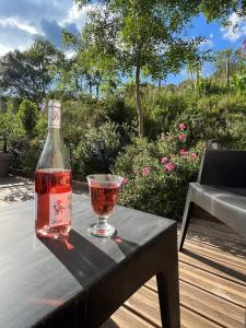 uma garrafa de vinho e um copo sobre uma mesa em La Maison Cayre, stylish house and terrace, Berlou, natural park em Berlou