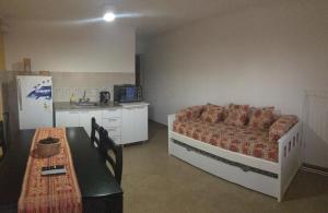 a bedroom with a bed and a table and a refrigerator at Liquidambar in Federación