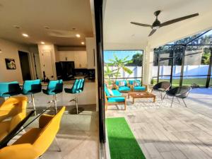 a living room with blue chairs and a table at Blue Door Retreat - Luxury Pool Home - sleeps 8 in Cape Coral