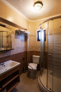 a bathroom with a toilet and a sink and a shower at Ebruli Hotel in Bozcaada