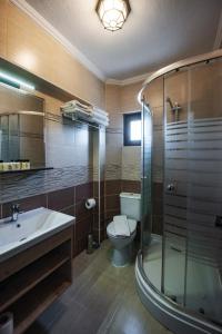 a bathroom with a toilet and a sink and a shower at Ebruli Hotel in Bozcaada