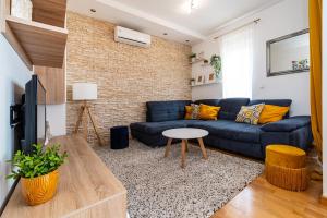 a living room with a blue couch and a table at Lipotica - Luxury, With Sea View in Nin