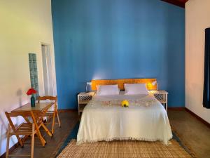 een blauwe slaapkamer met een bed met bloemen erop bij Pousada Maraú in Marau